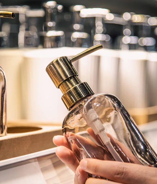 fermez un distributeur de savon liquide dans les mains des femmes dans le magasin min